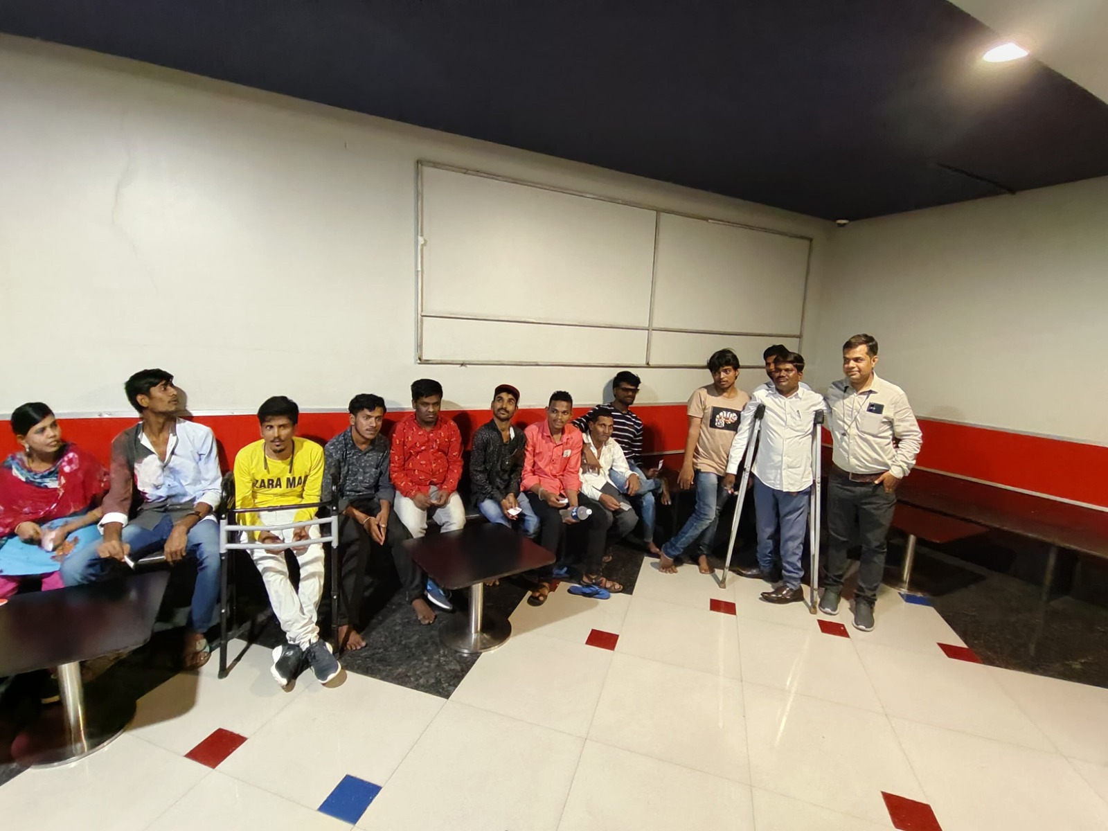 Beneficiaries and DigiAbility staff gathered in a waiting area at a camp